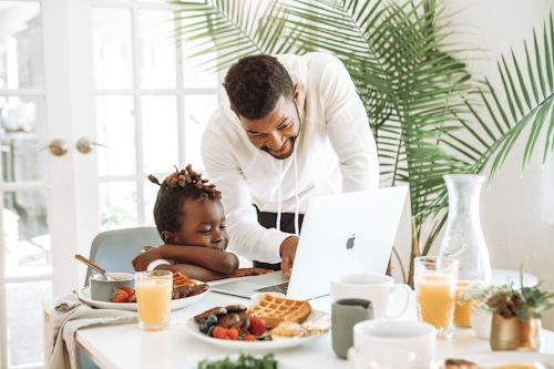 Two people using laptops at home